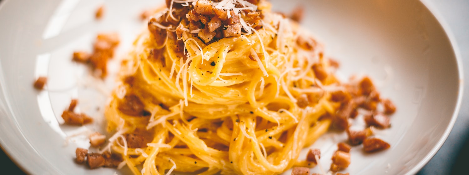 A bowl of spaghetti carbonara with black pepper