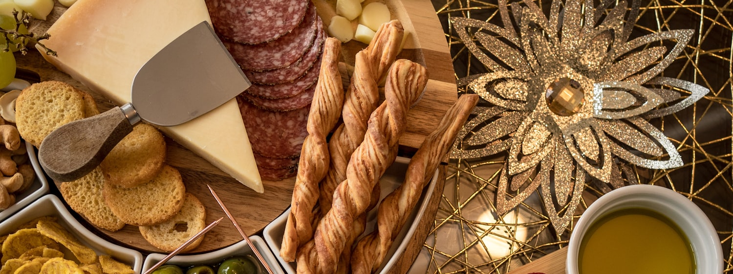 A wooden board of thinly sliced cured meats