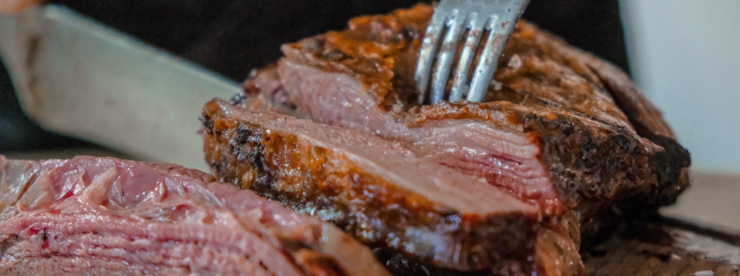 A roast leg of lamb with rosemary, carved on a wooden board