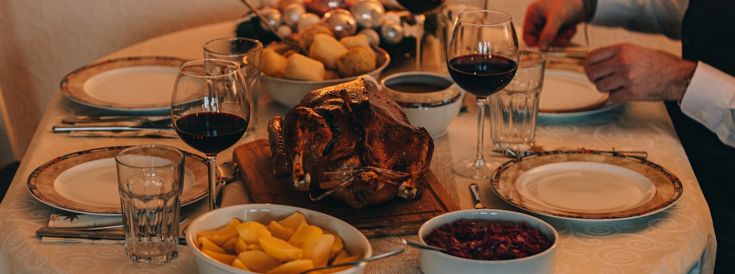 A festive table laid with roast dinner and drinks