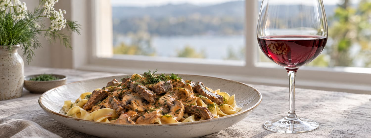 Beef stroganoff over egg noodles with a glass of translucent Pinot Noir